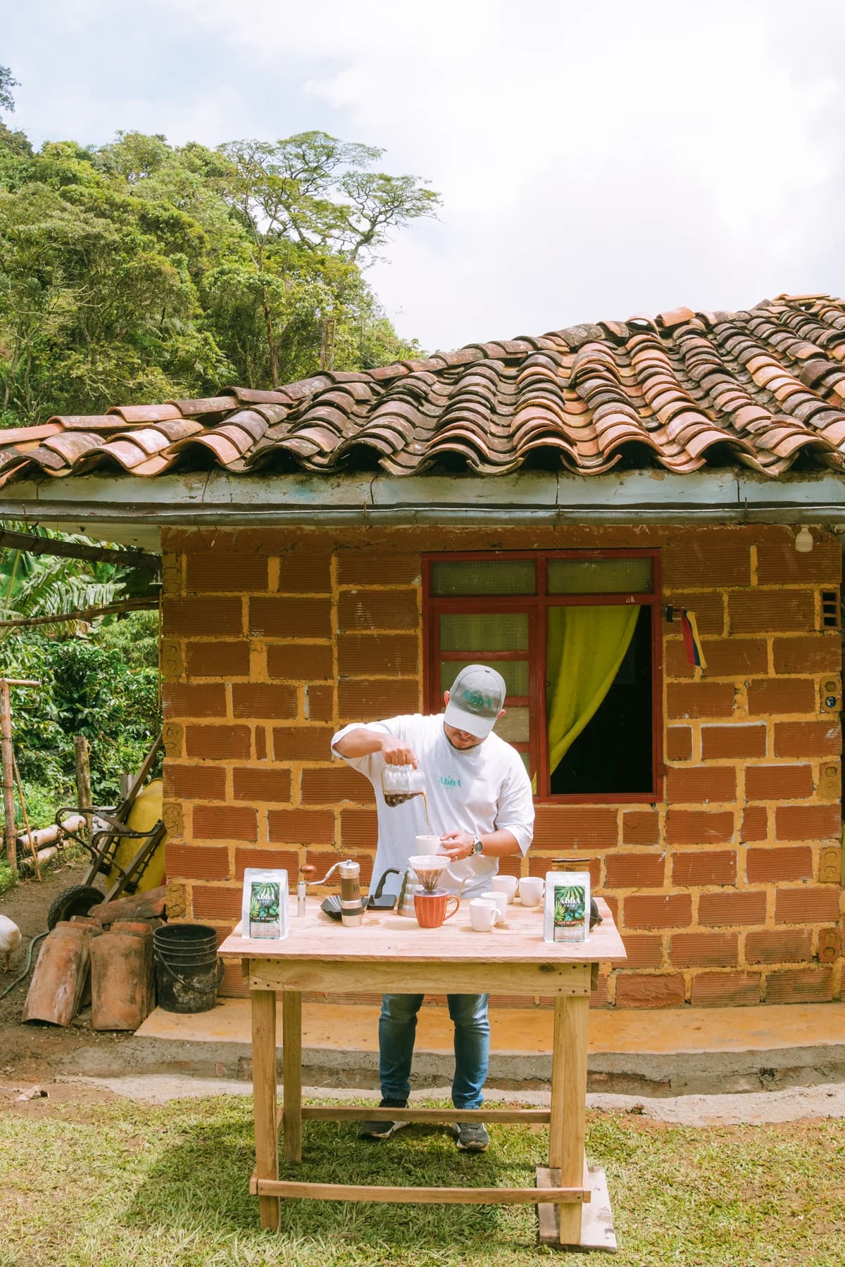 Alejo preparando café en V60 frente a la casa de la finca en Caldas